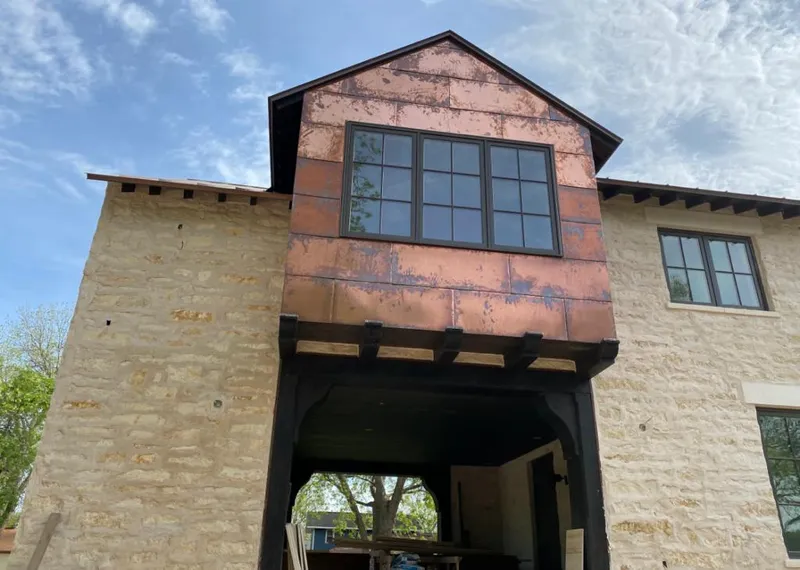 Copper metal panel facade on a stone building for Skylight Installation in Slinger
